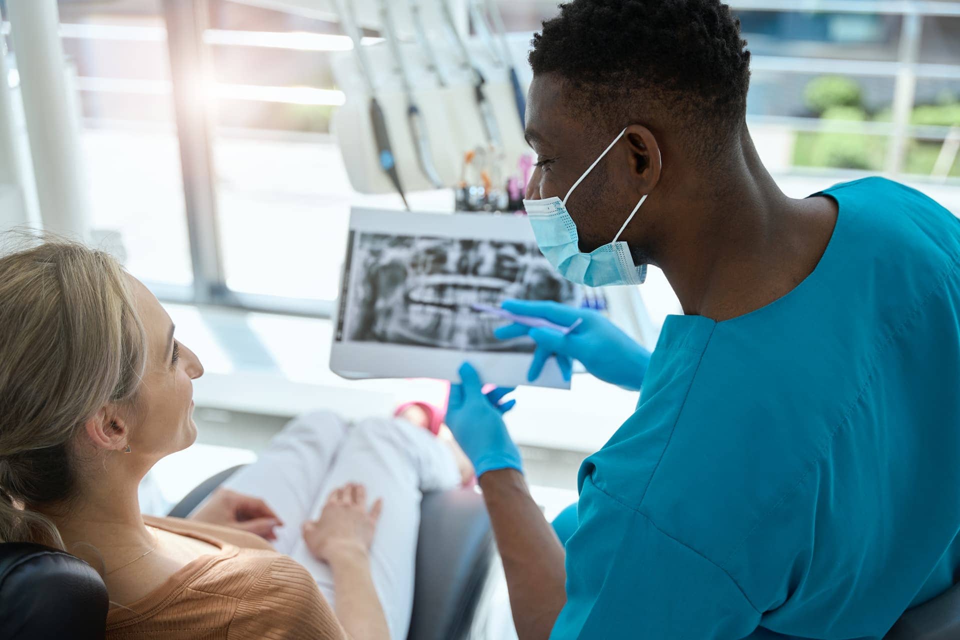 tech showing dental x-rays to patient